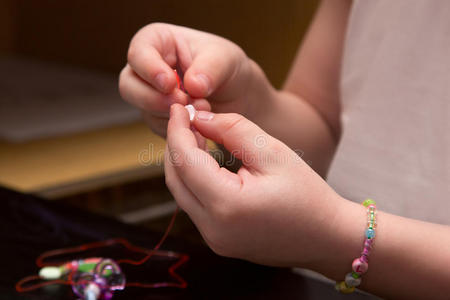 孩子的手把珠子串在线上