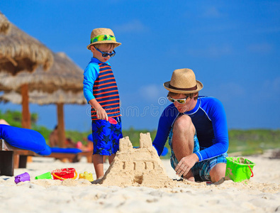 父子俩在海滩上建沙堡