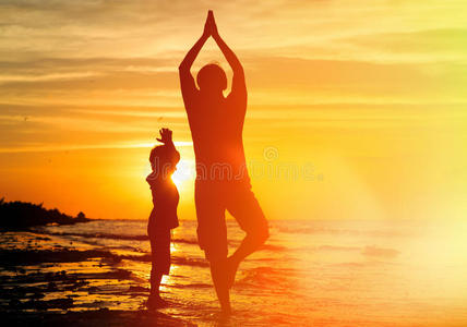 父亲和儿子在日落时做瑜伽