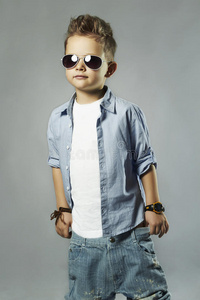 时髦的戴太阳镜的小男孩。穿着牛仔裤的时髦孩子