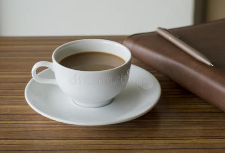 木桌上的咖啡杯和日记本
