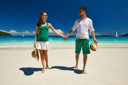 一对绿色的夫妇在塞舌尔的海滩上散步