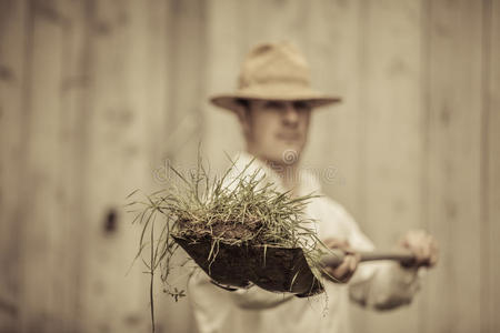 农民拿着一把装满草的铲子