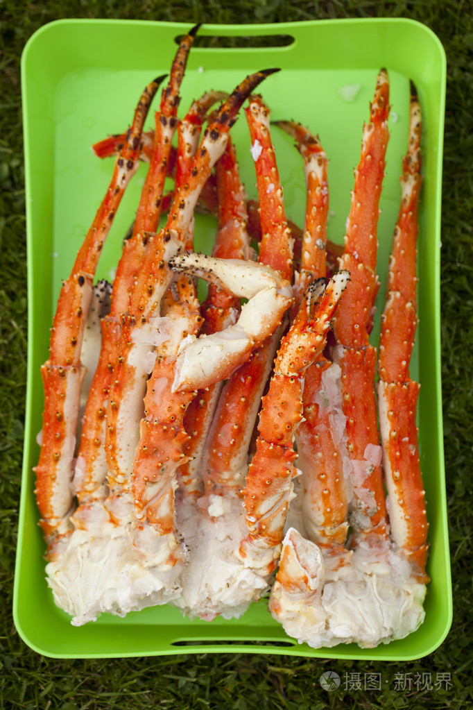 皇家国王螃蟹在绿色托盘上的煮腿