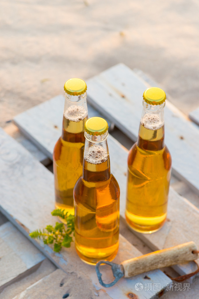 站在仿古木制板上的三个啤酒瓶