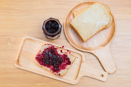 果酱制造商片与早餐的黑加仑子果酱面包照片