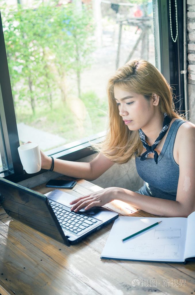 在咖啡馆与笔记本电脑工作的漂亮女孩