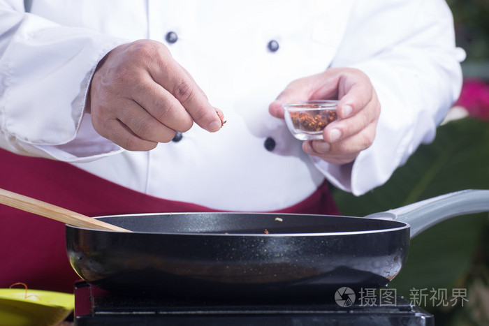 厨师把围绕辣椒烹饪垫泰国