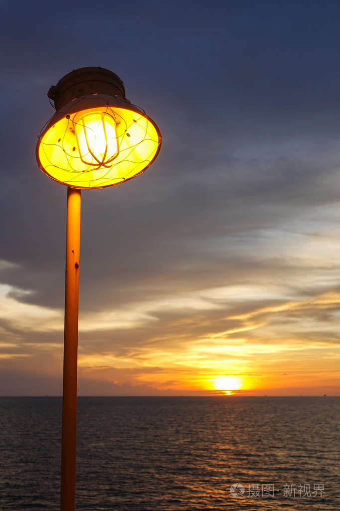 温暖的灯的照明和照明的日落在海上