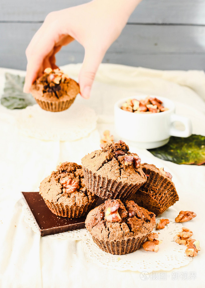 与核桃的巧克力松饼,女人手拿蛋糕