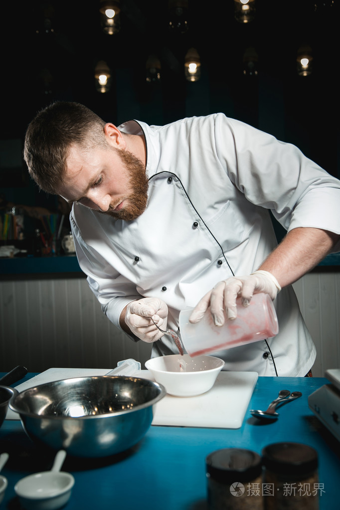 性格开朗的大胡子的厨师厨师烹饪时在厨房里做饭