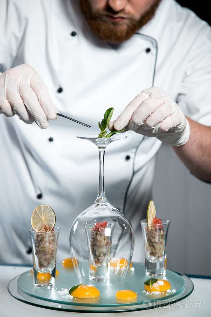 性格开朗的大胡子的厨师厨师烹饪时在厨房里做饭