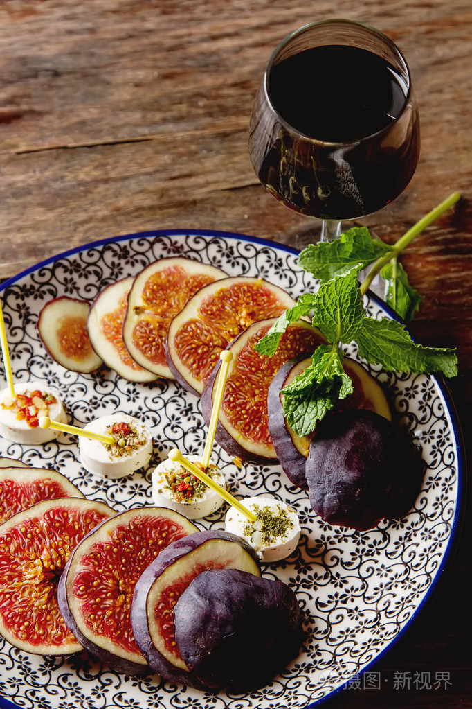 多汁成熟的无花果上板与山羊奶酪和利口酒木制