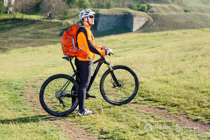 与装载自行车在绿色的草原上骑自行车旅游