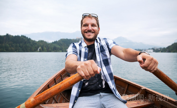 游客乘坐传统木船在斯洛文尼亚布莱德湖