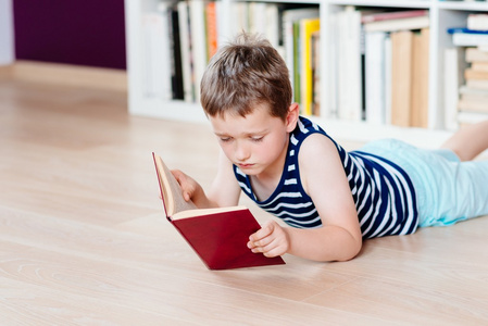 七岁的小男孩在图书馆看书照片