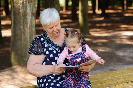 祖母和孙女在公园里读书图片