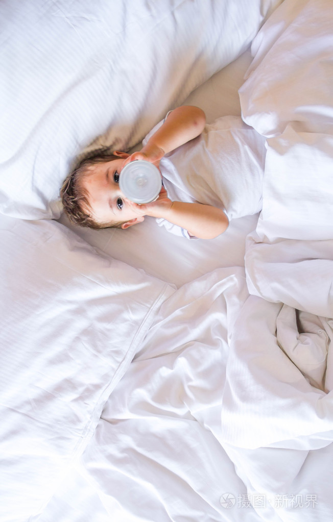 婴儿在床上喝牛奶