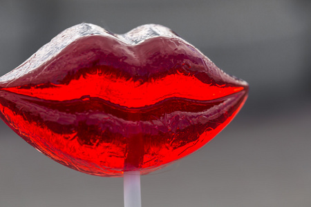 蓝色的天空的棒棒糖在一根棍子上的大红色棒棒糖照片