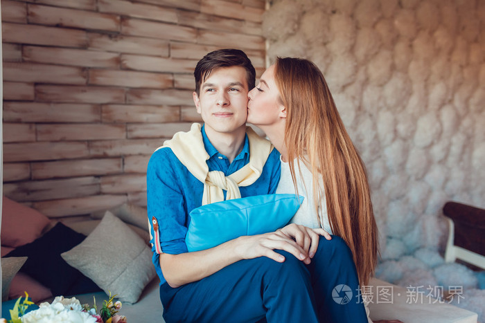 在坐的爱和女孩的脸颊上吻男人对年轻夫妇