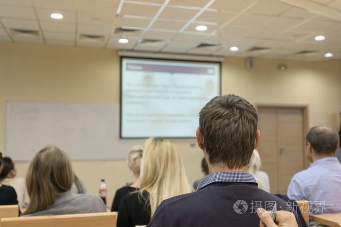 学生们聚精会神地听老师在白板附近的后视图