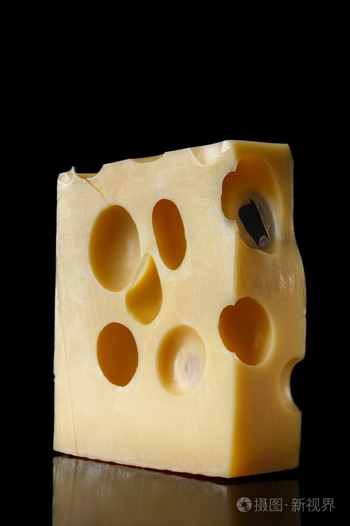 一块瑞士奶酪配上黑色的背景反映大洞孔食品艺术的简约风格奶酪特写