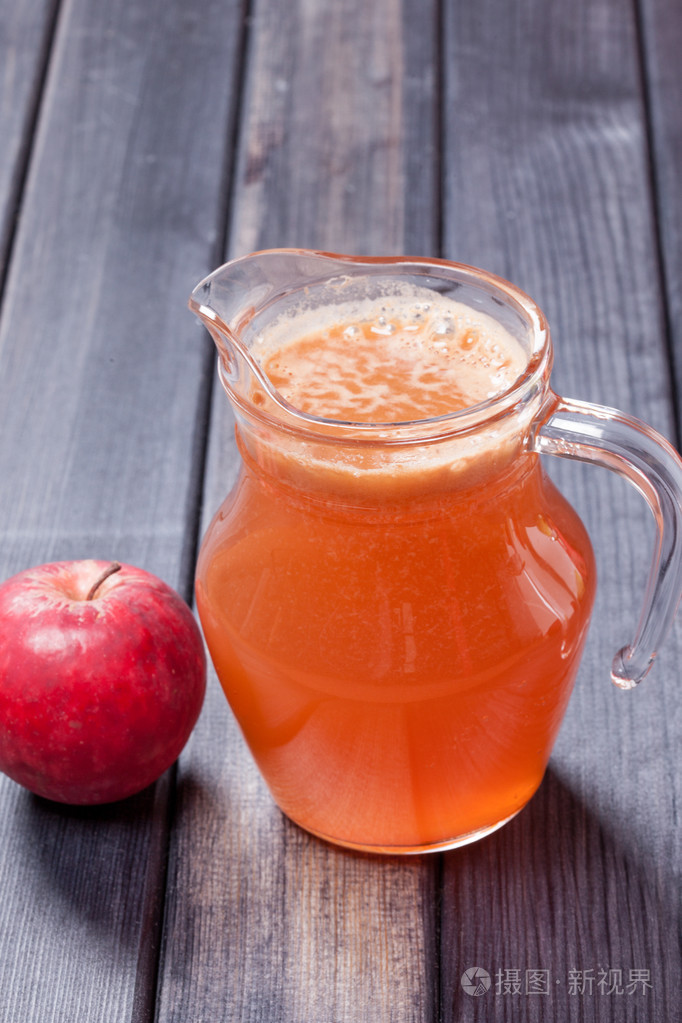 鲜榨苹果汁和红苹果在桌子上投手