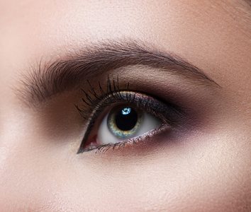 灰色的眉毛女性的眼睛特写.宏.完美的化妆和眉毛.美丽的灰色眼睛照片