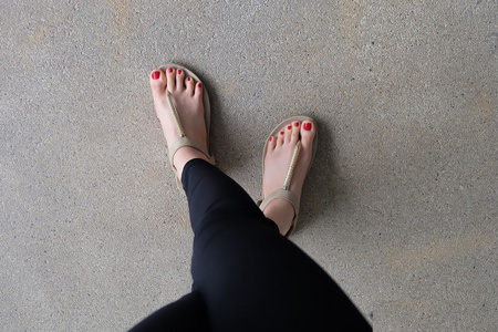 夹脚拖鞋女性脚穿着拖鞋或拖鞋户外红色指甲照片
