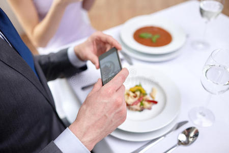一对夫妇在餐厅拿着智能手机的特写镜头