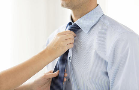 靠近女人的手，调整男人脖子上的领带