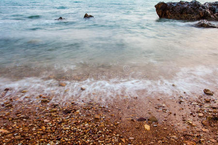 海滩上有沙子的砾石和波浪