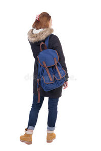 背景女人穿着冬天的夹克，背着背包向上看