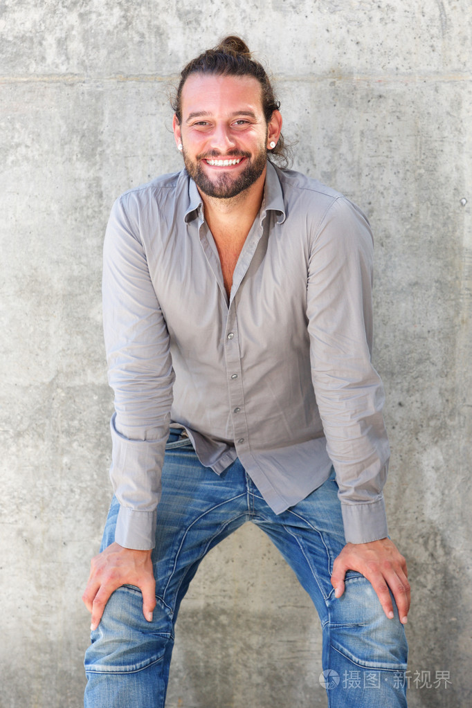 向前探出身子的男人微笑着双手放在膝盖上