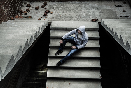 坐在楼梯上的肌肉男年轻人照片