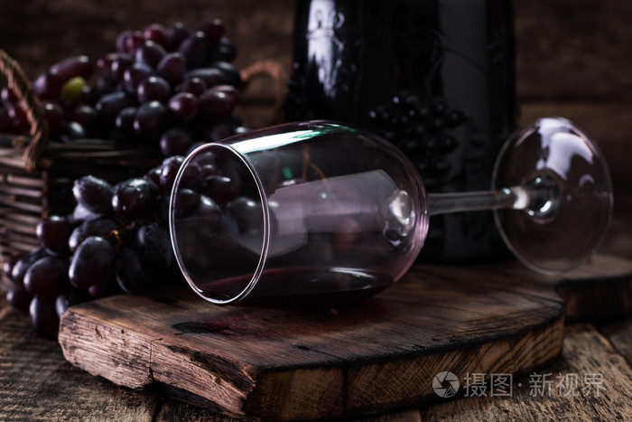 杯红酒，配上一个木制的背景的葡萄