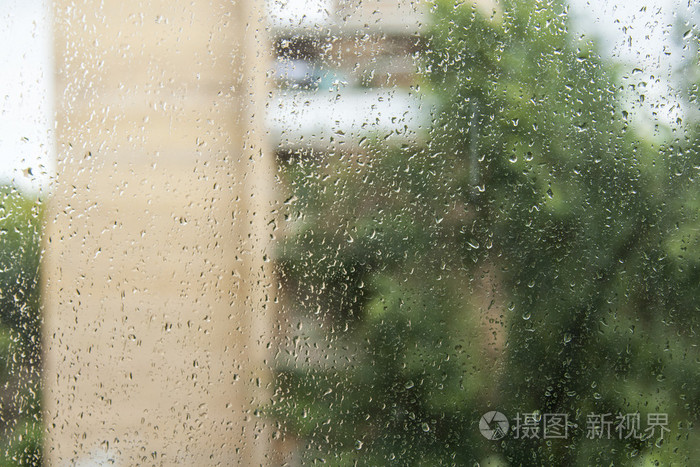 下雨时从窗户看风景.专注于玻璃上的水滴
