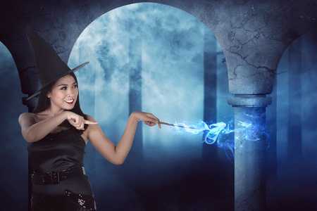 幸福亚洲女巫女人从她棒显示他的魔法照片