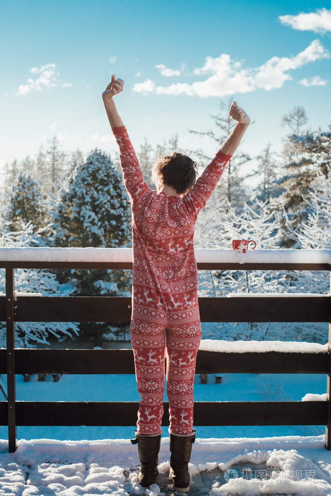 清晨舒展无忧无虑的年轻女子在雪地上覆盖阳台