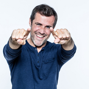 快乐的,英俊的年轻人笑着指着前方照片