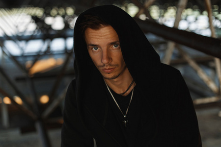 黑袍英俊的年轻男子,在黑袍罩照片