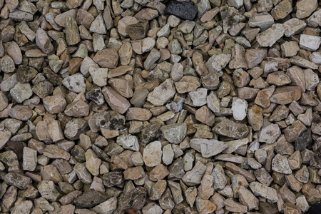 粉红色的左脚的鹅鹅卵石石头纹理地面米色谭粉红色白色照片