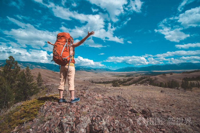 夫人旅游背包里的站在路上欣赏美丽的景色