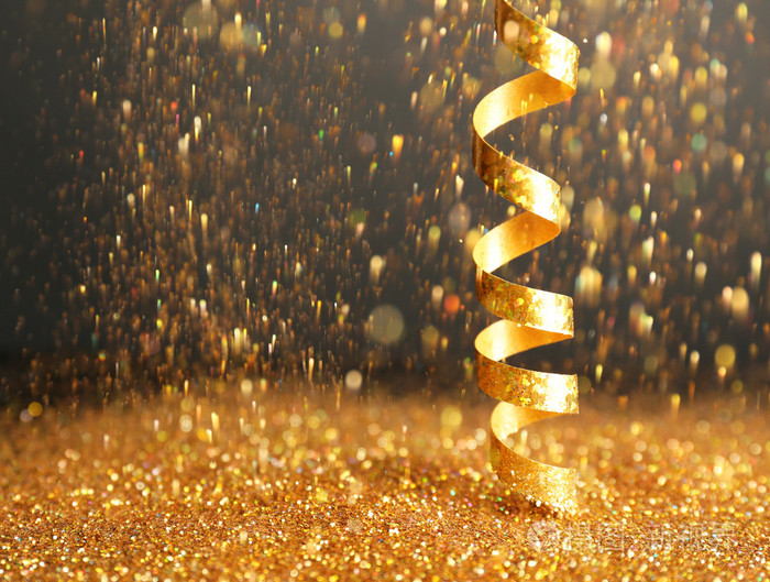 闪亮的金色流光和深色背景上闪光