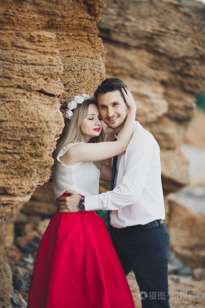 浪漫恩爱的夫妻,用石头和岩石海滩上散步