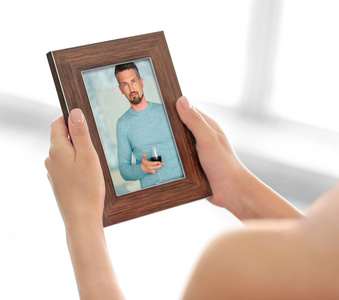 女性手拿相框与男人幸福记忆概念图片照片