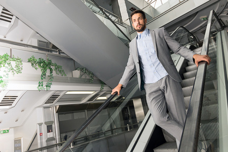 在通信上一步在自动扶梯上的现代城市人照片