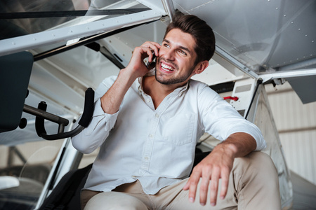 男人坐在小飞机和谈移动电话图片