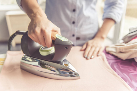 快乐的人熨衣服女人熨衣服照片