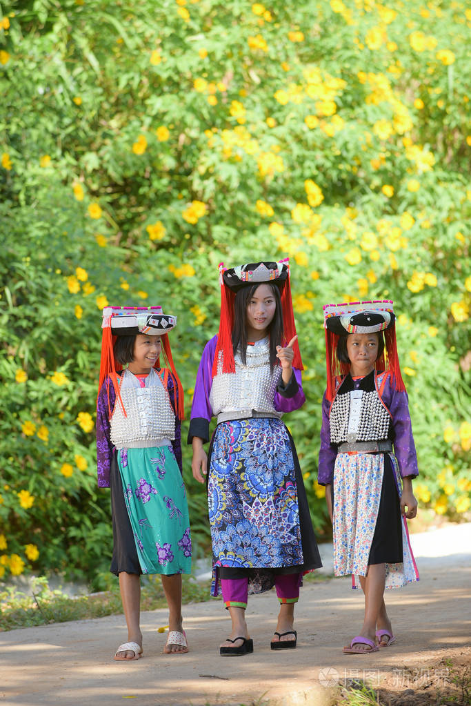 亚洲拉祜族夫人点手指同时与两个自定义衣服拉祜族部落女孩同行